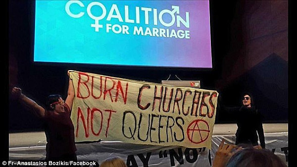 A Coalition for Marriage event was disrupted by protesters who stormed the venue and blocked the stage with a banner saying 'Burn churches not queers' (pictured)