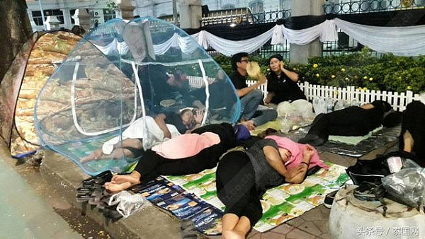 大量泰国民众早早到路边席地而睡、彻夜守候，等待观九世王葬礼