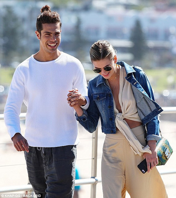 Cool and casual: Megan's beau cut a casual figure in a white sweater with black jeans ans Nike trainers