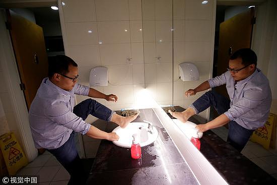 2016年4月20日，北京，午夜时分。一名互联网创业公司经理在公司卫生间洗脚。/视觉中国