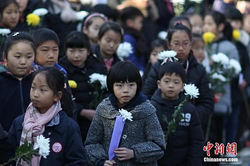 12月10日，在第四个国家公祭日来临之际，参加过当年战争的抗战老兵、侵华日军南京大屠杀遇难者家属、南京1213志愿者联合会的志愿者们来到南京光华门遗址公园，向这片曾经发生过激烈战斗的阵地献上和平岁月里的悼念菊花，祈祷永远和平。 中新社记者 泱波 摄