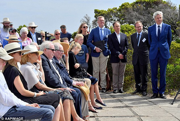 Health Minister Greg Hunt (third from the right standing) and Speaker Tony Smith (fourth from the right) join a memorial ceremony for Harold Holt at Cheviot Beach on Sunday