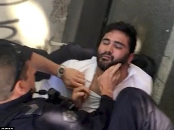 The man, who has a history of drug use and mental illness, spoke briefly to investigators on Thursday night after his dramatic arrest (pictured). The 32-year-old 'spoke about dreams and voices' as he lay under police guard in hospital