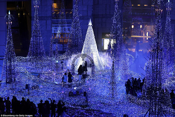 In Tokyo, city officials create a wonderland of lights and Christmas tree features that draw crowds of people (pictured)