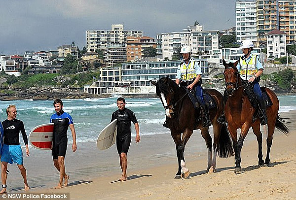 A NSW Police Mounted Unit patrol walks along the iconic sands of Sydney's Bondi Beach 