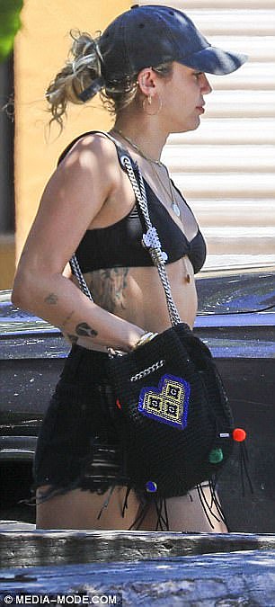 Australian summer: The Wrecking Ball star, 25, dressed appropriately for the hot climate in a skimpy bikini top and denim shorts