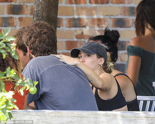 Close: The engaged couple put on an affectionate display at the restaurant, with Miley seen placing her hand on Liam's shoulders