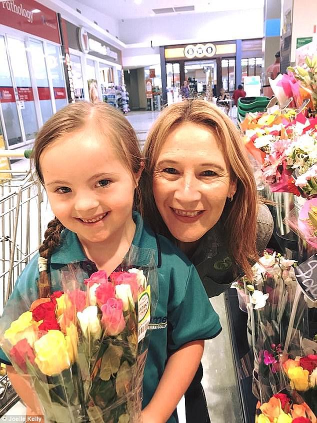 Josee is pictured with a Woolworths staff member after being gifted a bouquet of flowers