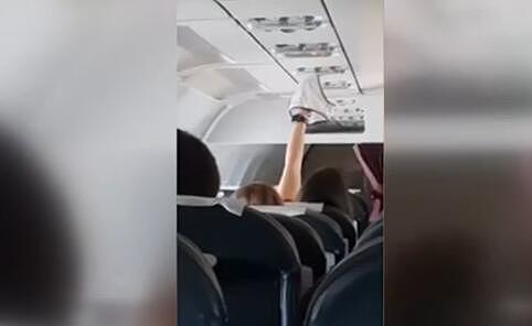 奇葩！女乘客飞机客舱内高举湿内裤试图烘干