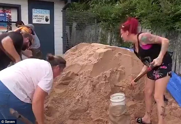 Parts of the New South Wales Hunter Valley were hit by 114mm of rain in just one hour from thunderstorms which hit early Wednesday morning (pictured are residents preparing for the wild weather)