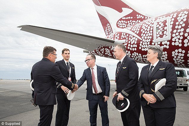 Alan Joyce (middle) shakes hands with captains in charge of the Qantas Dreamliner