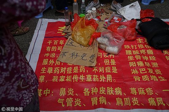 2016年10月10日，广西梧州步行街一男子，在地摊上面写出“医好付钱 不好免费”的招牌，声称可以治愈阳痿在内的多种疾病，吸引了很多老年人患者排队求医。/视觉中国