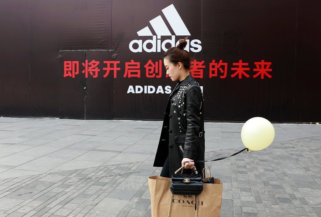 上周在北京，一名女子拎着纽约手包品牌蔻驰(Coach)的购物袋。美国公司为了中国巨大的消费市场竞相涌入这里。