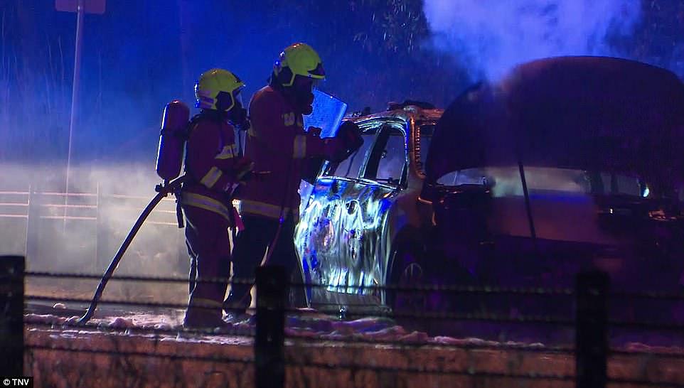 Putting out the blaze: The car was seen smoking after the firefighters doused the flames on the roadside on Sunday night
