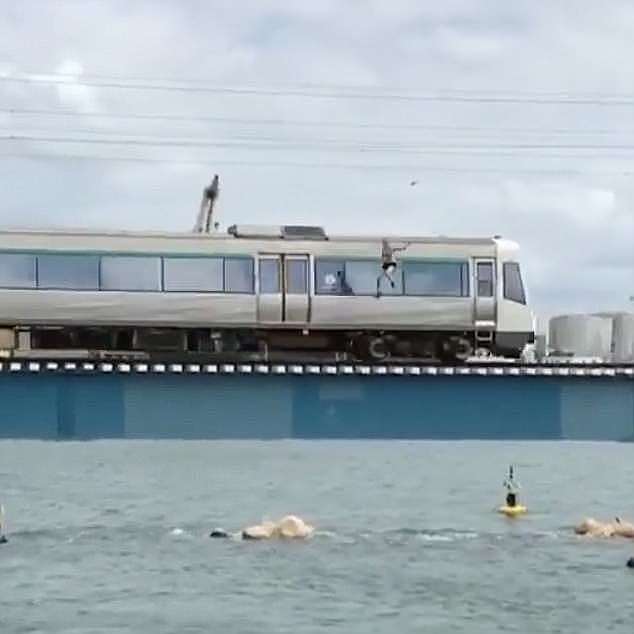 The video shows the man on the last carriage of the train as it starts to cross a rail bridge in Fremantle, Western Australia before he leaps off into water five metres below 