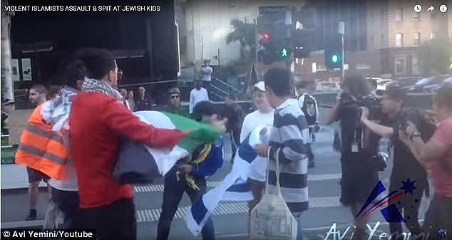This is the moment a protester spits on an Israeli flag during a clash in Melbourne over Palestine