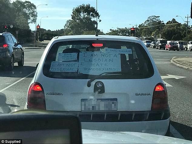 A motorist has captured the moment a car with horrible racist and homophobic slogans covering the back windshield ventured onto the streets of Perth