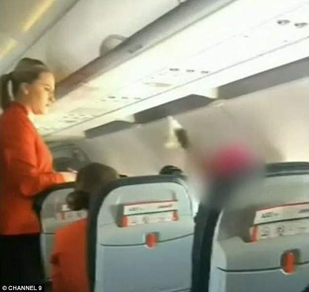A woman has been hauled off a flight by federal police after hurling abuse at passengers and crew members