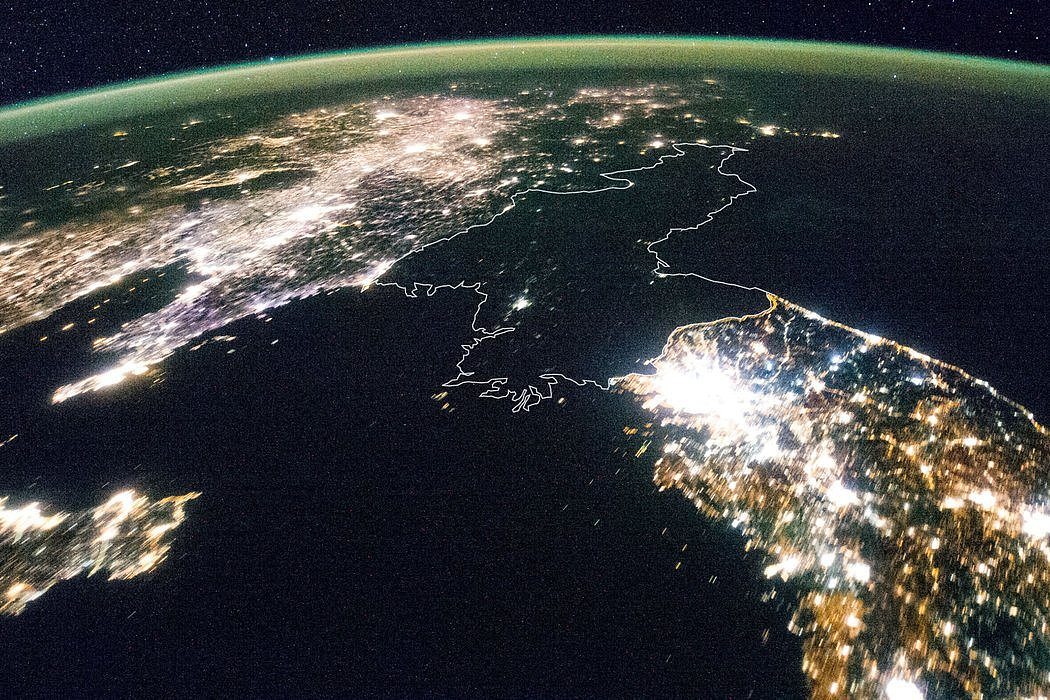 夜晚，夹在中国和韩国明亮光芒之中的黑暗朝鲜。那一点灯光是朝鲜的首都平壤。