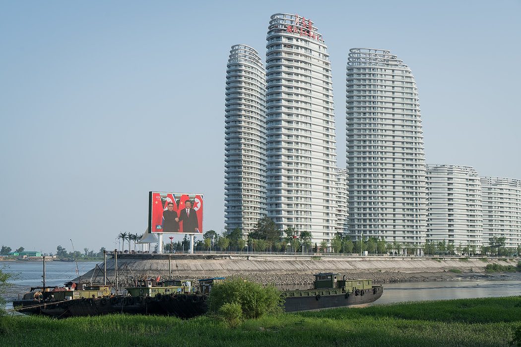 上个月，位于中国丹东、靠近朝鲜边境的一栋豪华公寓大楼。大屏幕播放着中国国家主席习近平和朝鲜领导人金正恩之间一系列会谈的画面。