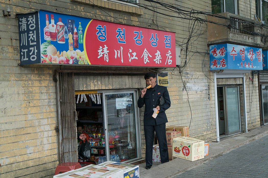 丹东一家小杂货店外的朝鲜男子。在一些边境城市，朝鲜人和中国人一起工作和生活。