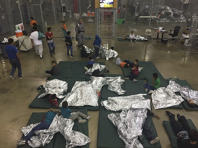 非法入境的中南美偷渡客被关押在德州移民执法单位临时安排的拘留中心，睡在当局提供的保暖床单上。(Getty Images)
