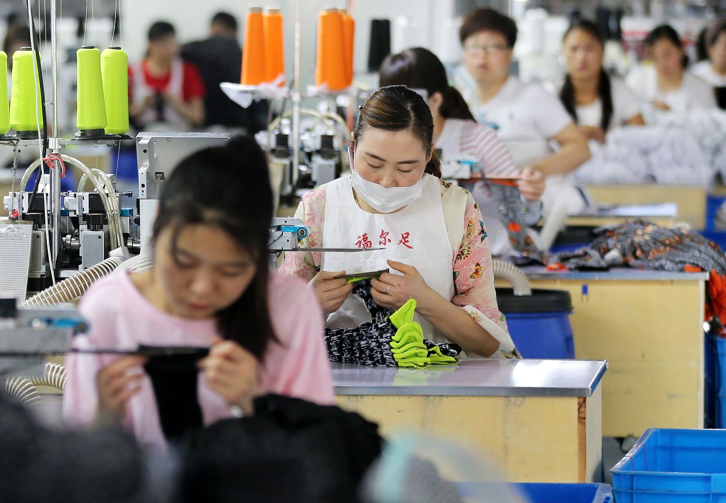 图为安徽淮北的一家袜子工厂作业员正在生产线上。（Getty Images）