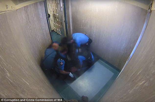 After being pushed against a wall, the prisoner is slammed to the ground and held by four officers for a several minutes before he is released