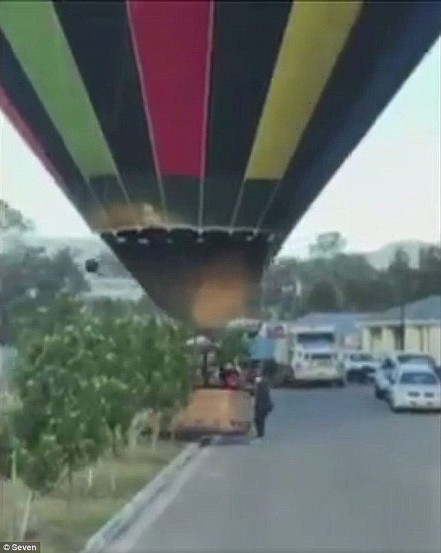 A group of people were seen pushing the balloon off the road and onto a vacant block of land (pcitured)