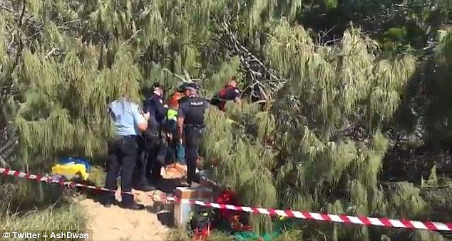 A dramatic rescue operation is underway after a man fell into a hole and was left buried up to his neck at a Urangan beach near Hervey Bay, Queensland 