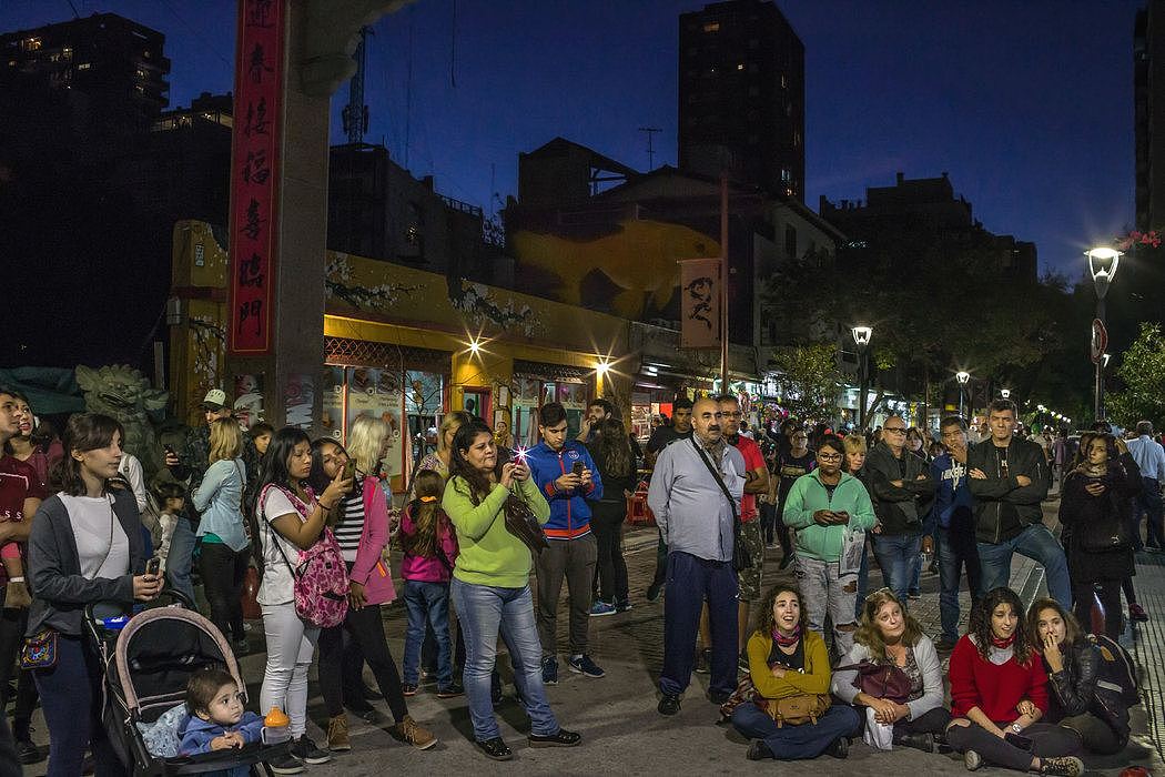 在有大量华人的布宜诺斯艾利斯，居民们在听街头小提琴手的演奏。