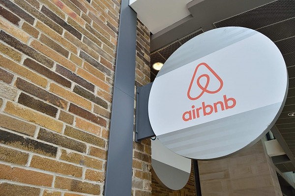 a-sign-depicting-the-airbnb-logo-juts-out-from-a-brick-wall-data.jpg,0
