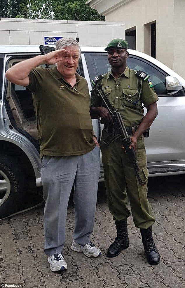 A Nigerian armed guard (right) who escorted Arthur Birch (left) to the airport on Monday posed with for photos with his VIP passenger