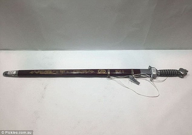 A samurai sword lies within its maroon case and is up for someone who may collect the weapons