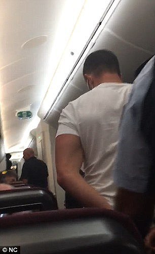 Other passengers reveal the man was shouting and swearing before being tamed by passengers and crew members and taken to the back of the plane
