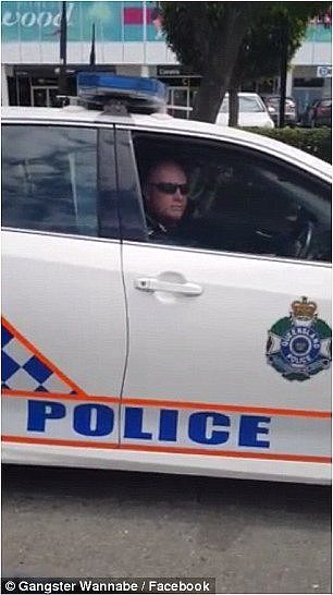 The video footage shows a vehicle pull up next to a Queensland police car and the officer rolling down his window