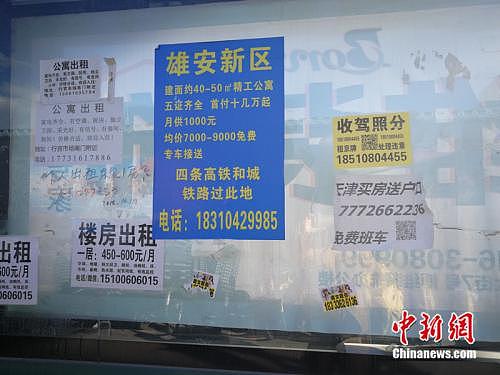 街道公交站牌旁边的综合宣传栏里贴着雄安新区的广告。<a target='_blank' href='http://www.chinanews.com/' >中新网</a>记者 邱宇 摄