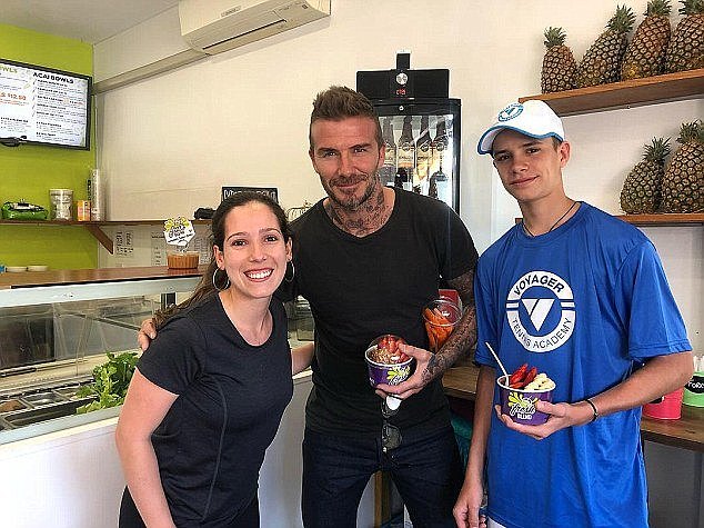 All smiles: David Beckham (centre) and his son Romeo (right) posed withÂ Fresh Blend owner Katrina Magill (left) after buying two aÃ§aÃ­ bowls for themselves and a peeled carrot for Victoria