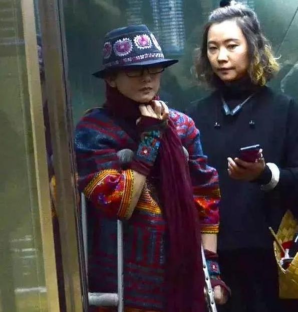 60岁杨丽萍现身机场，拄着拐杖走路吃力，几十万养的长指甲不见了