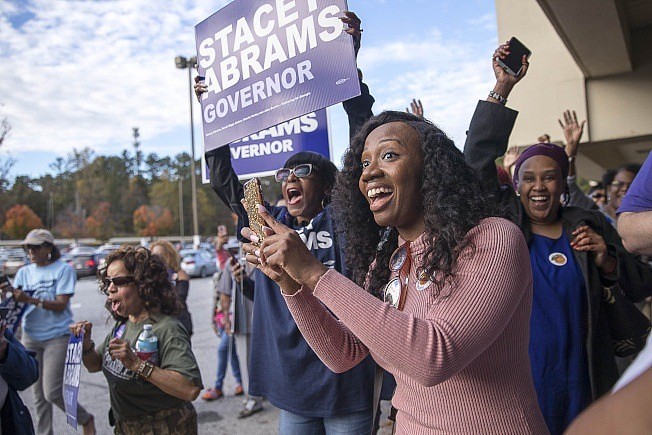 乔治亚州非洲裔州长候选人艾步兰的支持者，在投票站前为她热心拉票。 (美联社)