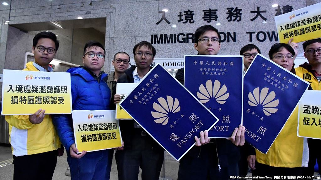 香港新民主同盟成员手持示威道具护照，讽刺孟晚舟拥有3本香港特区护照，质疑入境处滥发香港特区护照。 (摄影: 美国之音汤惠芸)