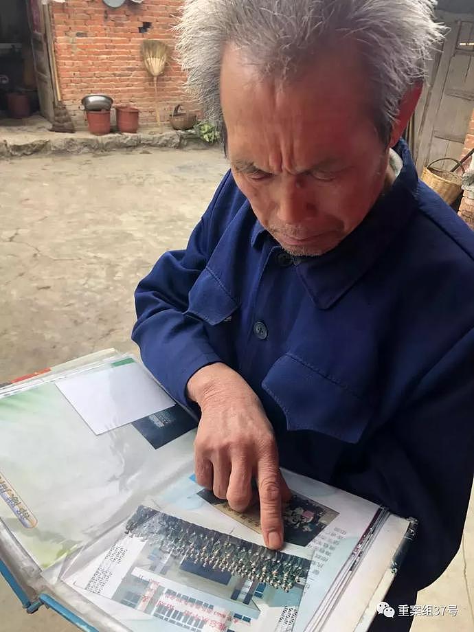 ▲张福如已经68岁，他在院子里翻儿子的照片册。新京报记者 杜雯雯 摄