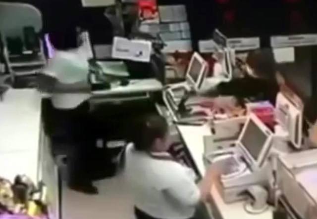 歹徒在柜台前取刀抢劫。 翻摄自YouTube