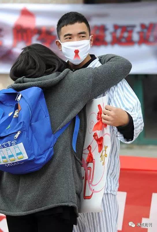 防艾志愿者穿上病号服，模拟患者接受同学的拥抱。视觉中国供图