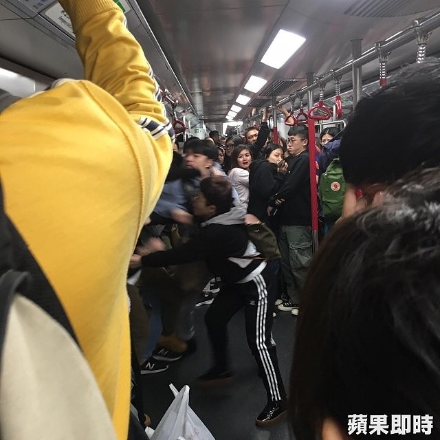 地铁乘客吓得赶紧远离打架人群。 香港《苹果日报》