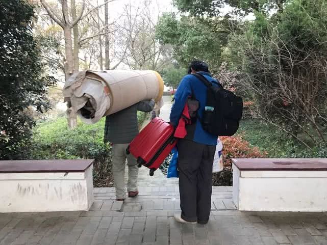 被劝离后，朱路路（右）将行李从墓园搬走。新京报记者祖一飞 摄