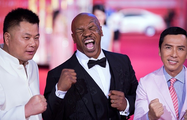 在中国被控诈欺的施建祥(左)在美生活奢华。 图为他2015年6月在上海一项影展上和拳王泰森(中)等合影。 (Getty Images)