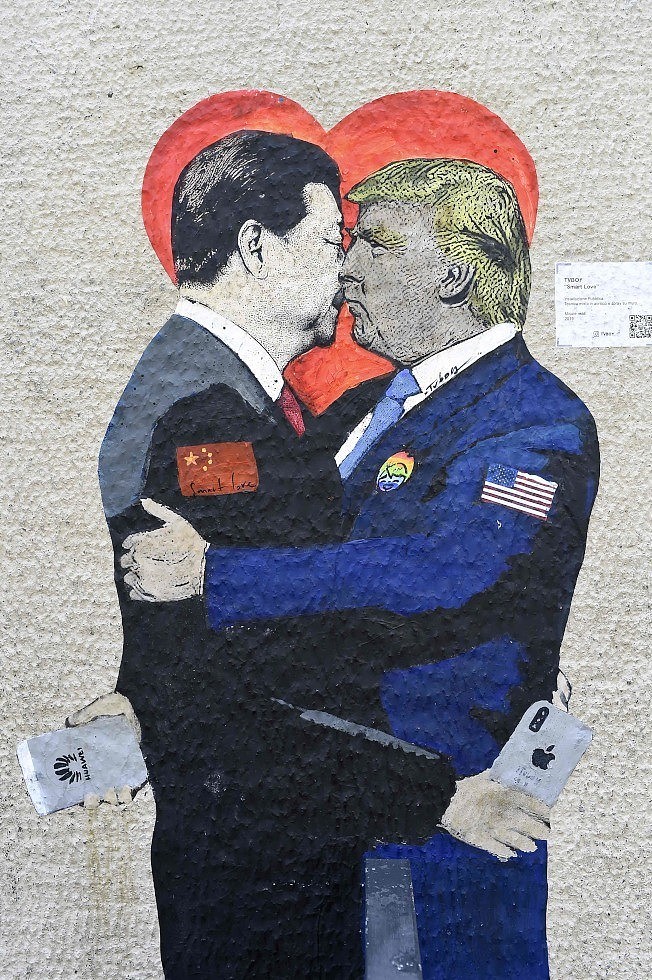义大利街头艺术家在米兰创作的漫画，题为「智慧的爱」，图中的川普拿着华为手机，习近平拿着苹果手机。 (Getty Images)