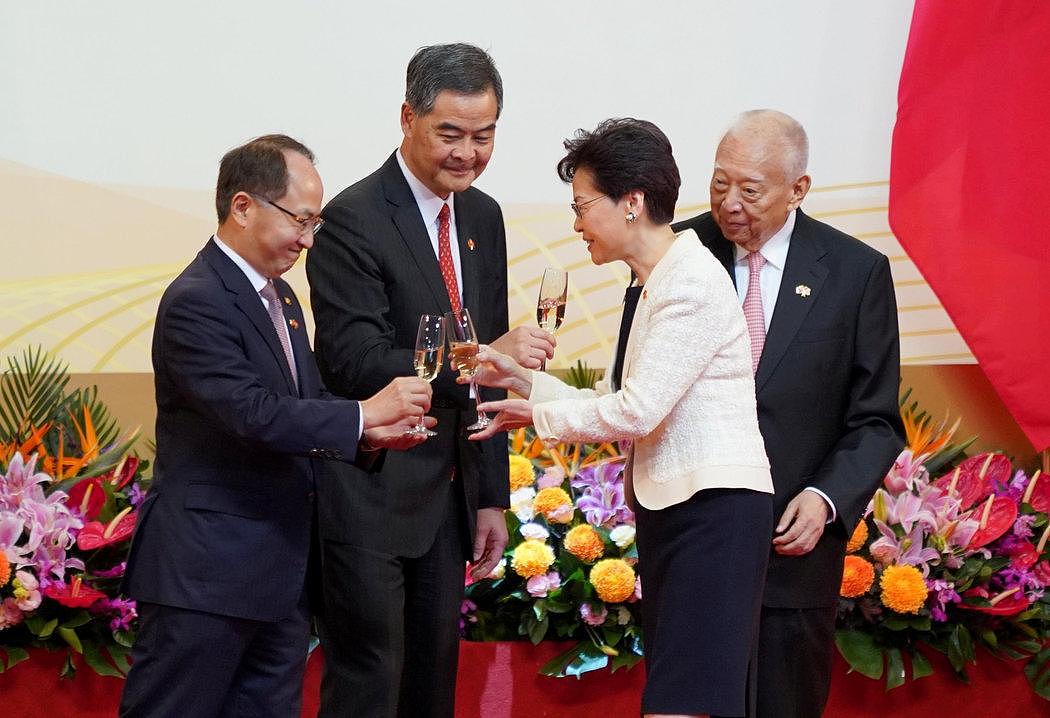 在周一上午的庆祝仪式上，香港行政长官林郑月娥与其他官员碰杯，包括香港中联办主任王志民（左）。