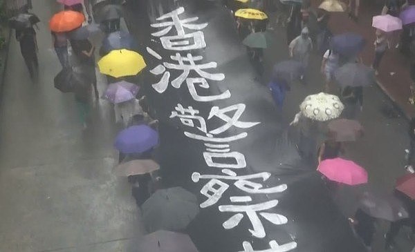 ▲▼民众不畏风雨加入「反蒙面法」游行。 （图／翻摄自香港电台视像新闻）